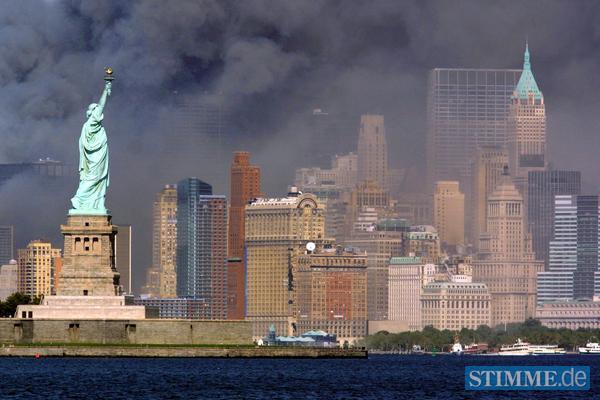 Die Freiheitsstatue steht am Dienstag (11.09.2001) vor der Insel Manhatten in New York, die in eine Rauch und Staubwolke geh&uuml;llt ist.