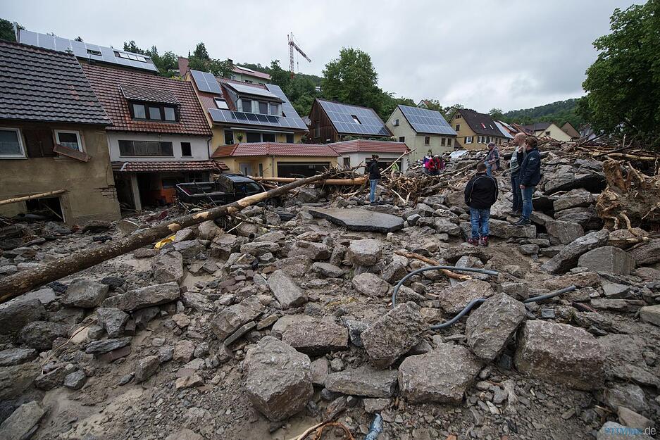 Überschwemmte Straßen, zerstörte Häuser und Autos; überall Schlamm und Schutt.