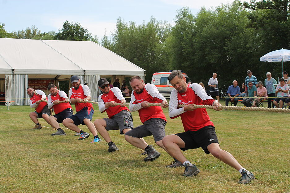 Zupacken, stabile Schuhe in den Boden stemmen: Mit vollem K&ouml;rpereinsatz, angespannten und fokusierten Gesichtsz&uuml;gen versuchen Mannschaften, ein Seil um wenige Meter auf ihre Seite zu ziehen.