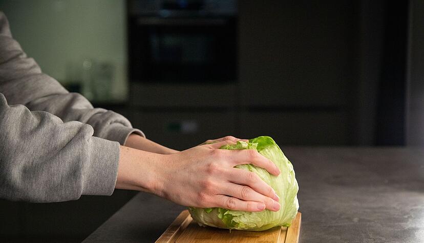 Schritt 1: Den Salat mit dem Strunk nach unten auf die Arbeitsfl&auml;che schlagen.