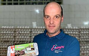 Georg Heitlinger, Legehennenhalter in Eppingen, zeigt eine Schachtel mit dem Huhn-und-Hahn-Logo.