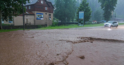 Ein Auto steht auf einer überfluteten Straße nach heftigen Unwettern. Foto: dpa Ein Auto steht auf einer überfluteten Straße nach heftigen Unwettern. Foto: dpa