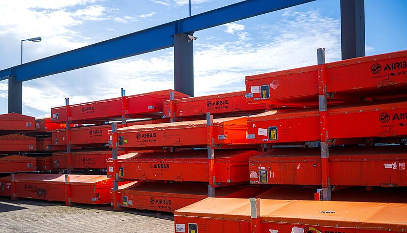 Vor der Werkhalle warten besch&auml;digte Fahrzeugteile auf die Reparatur.