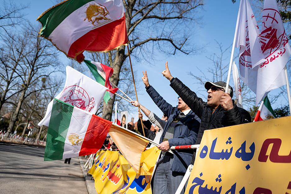 Die Auswirkungen des Nahost-Kriegs treffen auch Berlin. Dort nehmen Menschen an einer Demonstration des Nationalen Wiederstandsrat Irans mit Flaggen vor der iranischen Botschaft teil.