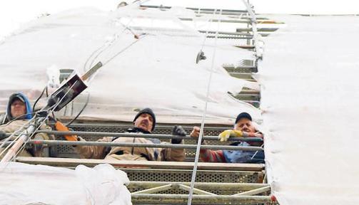 Mitarbeiter der Firma Alwert ziehen einen Sandstein hoch. Vor allem an den Ecken des Kirchturms gibt es erhebliche Sch&auml;den.Fotos: Thomas Braun