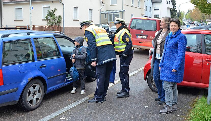 Die Polizisten vom Referat Pr&auml;vention sprechen vor der Gr&uuml;newaldschule Eltern an, die dort halten, wo es f&uuml;r andere gef&auml;hrlich werden kann.
Foto: Stefanie Pf&auml;ffle
