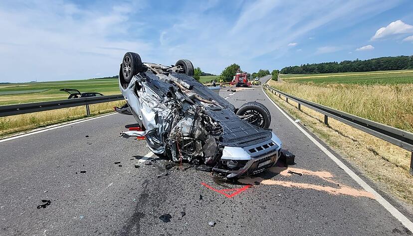 Ein Unfallfahrzeug liegt nach einem Frontalzusammenstoß auf dem Dach.