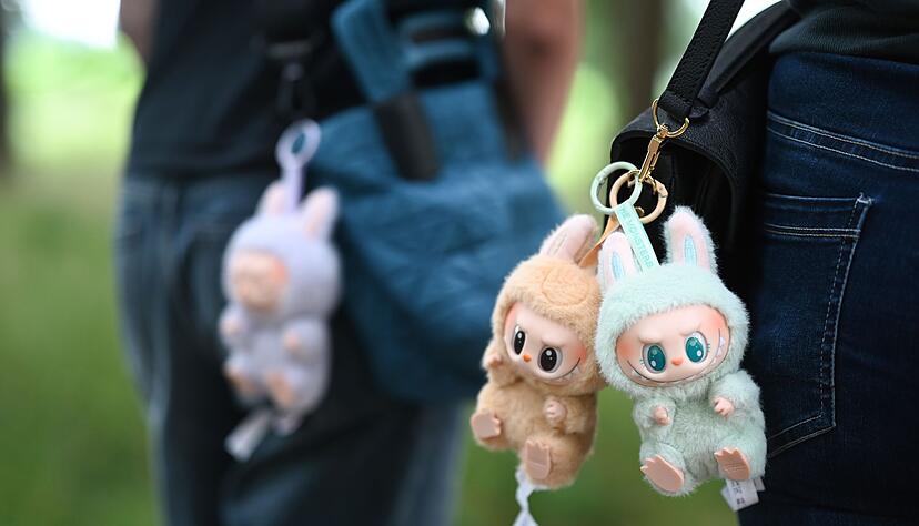 Zwei Frauen tragen Labubu-Anh&auml;nger an ihren Umh&auml;ngetaschen. (Archivbild)