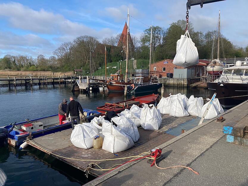 Gro&szlig;e Sands&auml;cke, sogenannte Big Bags, werden im Hafen von Kirchdorf auf Poel per Kran auf einen Ponton abgeladen.