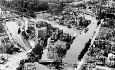 Neckarinseln: Vorn in der Mitte die 1945 gesprengte Neckarbrücke (heute Friedrich-Ebert-Brücke). Dahinter die Hefenweiler-Insel, auf der heute Insel-Hotel und Experimenta stehen. Links der Wilhelmskanal. Das Hospitalgrün über dem Hefenweiler war damals noch Insel, weil dahinter ein Flussarm vorbei führte, der später mit Trümmerschutt zugeschüttet wurde. Auf dem Hospitalgrün stehen heute Stadtbad Soleo, Kolbenschmidt-Arena, Mini-Golf-Anlage und Rollschuh-Stadion.