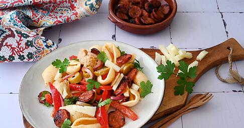 Diese Zutaten bringen Tapas-Feeling zwischen die Muschelnudeln: Chorizo, Manchego, Artischocken, Oliven, Paprika - und ein Schuss Sherry.