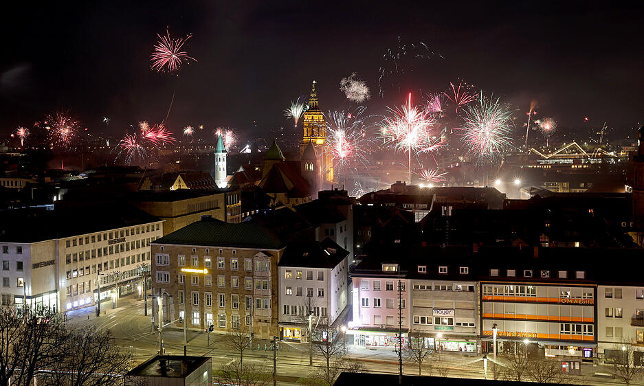 Über den Dächern der Stadt zündeten die Feuerwerksraketen. Über den Dächern der Stadt zündeten die Feuerwerksraketen.
