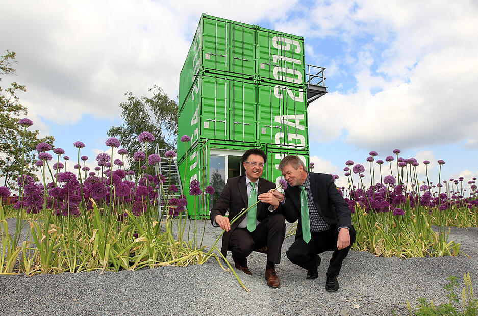 Um die knallig grüne Infobox auf dem Buga-Gelände hat sich im Mai 2011 das satte Violett von Zierlauch gesellt. Friedrich Wagner (links), Interims- Geschäftsführer der Buga-GmbH, und Hans-Peter Barz, Chef des Heilbronner Grünflächenamtes, treiben die Vorbereitungen für dieses Jahrhundertprojekt voran. Ihre Krawatten ziert der Schriftzug Buga 2019.