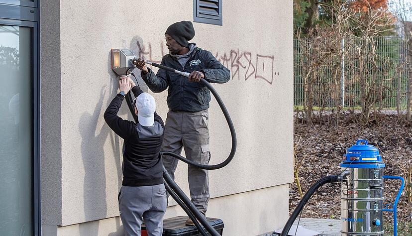 An einer Hauswand der TSG Heilbronn entfernen zwei junge Erwachsene Graffiti. Jugendamt, Seehaus und Polizei sind am Projekt beteiligt.
Foto: Mario Berger