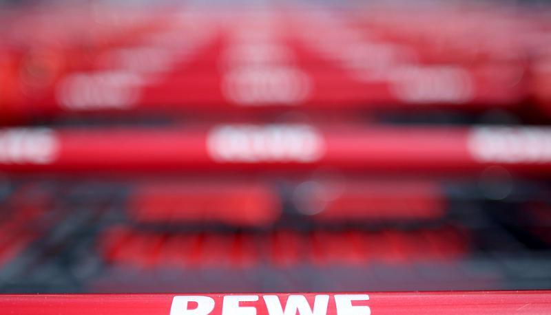 Einkaufswagen stehen vor einem Rewe Supermarkt. Einkaufswagen stehen vor einem Rewe Supermarkt.