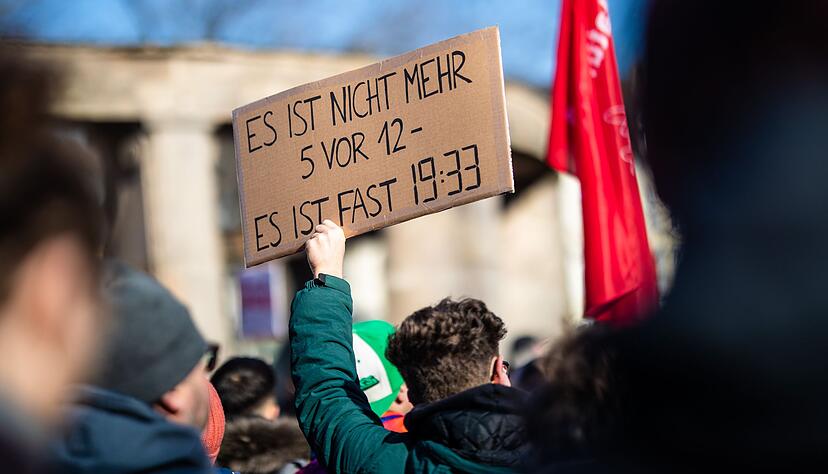 Mit Plakaten, Flaggen und Bannern protestieren die Demonstranten gegen die gemeinsame Abstimmung von Union und AfD f&uuml;r eine sch&auml;rfere Migrationspolitik.