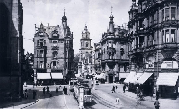 Das Barbarino-Eck an der Kaiserstraße  1934, nach dem gleichnamigen Zigarrengeschäft (mi) benannt. Die vom Handel geprägte Stadtmitte; die Straßenbahn, liebevoll Spatzenschaukel genannt, verkehrt im Zentrum.