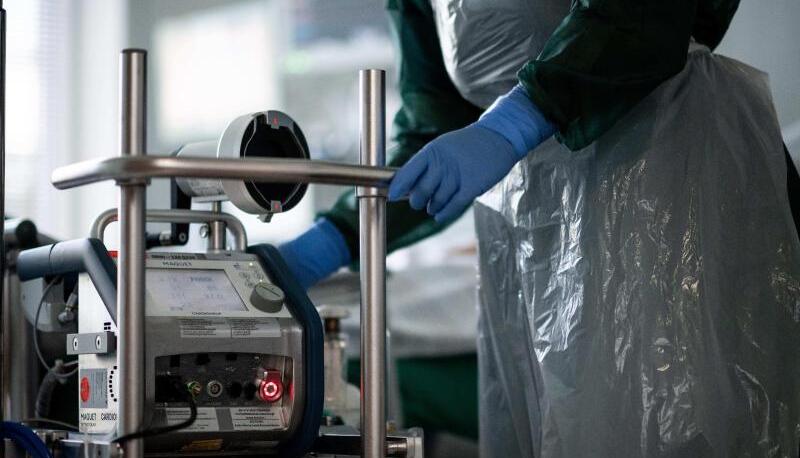 Eine Mitarbeiterin der Pflege steht in einem Zimmer einer Corona-Intensivstation. Foto: dpa Eine Mitarbeiterin der Pflege steht in einem Zimmer einer Corona-Intensivstation. Foto: dpa