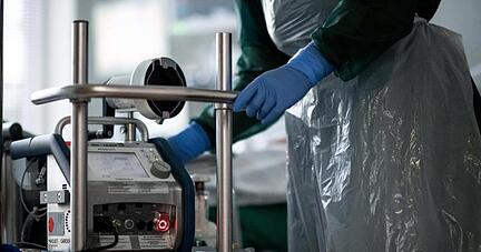 Eine Mitarbeiterin der Pflege steht in einem Zimmer einer Corona-Intensivstation.