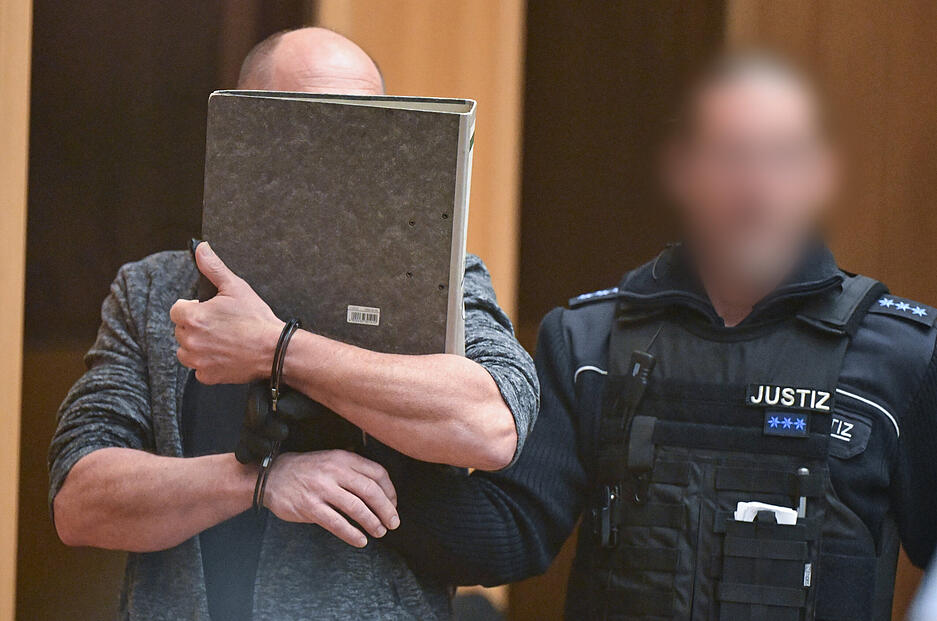 Ein Angeklagter wird in Stuttgart-Stammheim beim Beginn eines Prozesses um Reichsbürger, die mutmaßlich einen Umsturz in Deutschland geplant haben sollen, in den Gerichtssaal geführt.