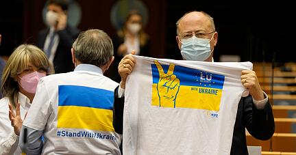 Ein Mitglied des Europäischen Parlaments hält ein T-Shirt in den Farben Blau und Gelb zur Unterstützung der Ukraine. Ein Mitglied des Europäischen Parlaments hält ein T-Shirt in den Farben Blau und Gelb zur Unterstützung der Ukraine.
