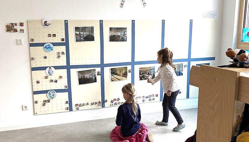 Zwei Mädchen beraten, welchen Funktionsraum sie als nächstes nutzen wollen und pinnen ihre Fotokarte unter das entsprechende Bild auf der Orientierungstafel. Zwei Mädchen beraten, welchen Funktionsraum sie als nächstes nutzen wollen und pinnen ihre Fotokarte unter das entsprechende Bild auf der Orientierungstafel.