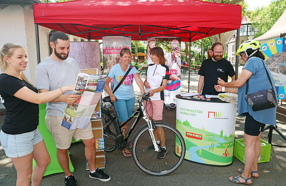 Besucher informieren sich an einem Stand über nachhaltige Mobilität.