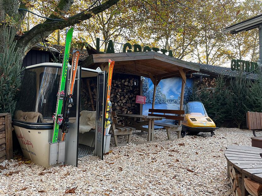 Winterliche Atmosphäre  mit alter Skigondel und Schneemobil. Hier können Gäste in der Nähe des Lagerfeuers entspannen. Winterliche Atmosphäre  mit alter Skigondel und Schneemobil. Hier können Gäste in der Nähe des Lagerfeuers entspannen.