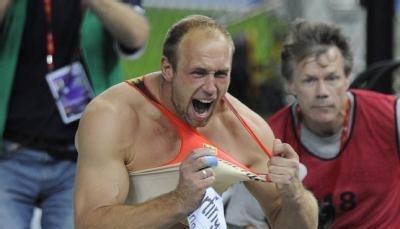 Weltmeister Robert Harting zerreist nach dem Sieg sein Trikot.