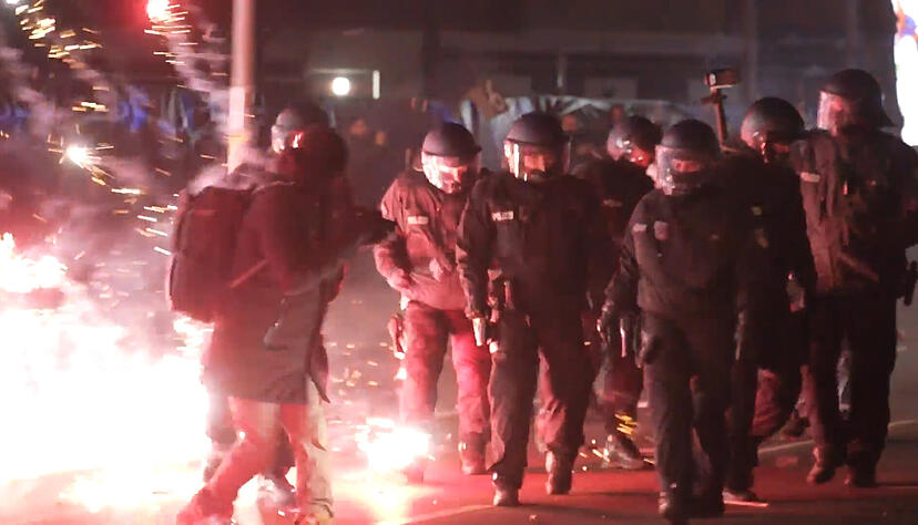 Einsatzkräfte der Polizei stehen in der Silvesternacht zwischen brennendem Feuerwerk in Neukölln. Einsatzkräfte der Polizei stehen in der Silvesternacht zwischen brennendem Feuerwerk in Neukölln.