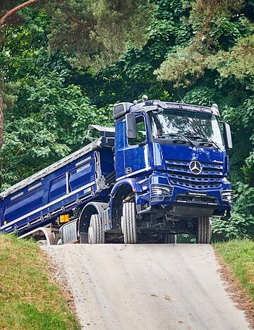 Über Hügel, Stock und Stein: Wer fernab gewöhnlicher Straßen Lasten bewegen will, greift zu Trucks wie dem Arocs 4151 von Mercedes.