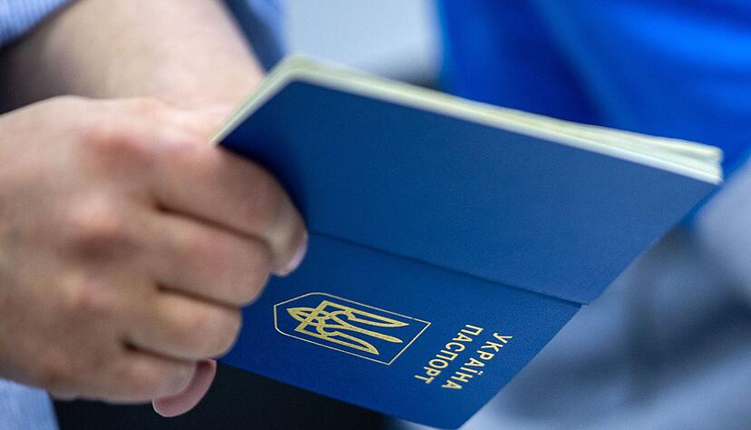 Ein Mann hält einen ukrainischen Reisepass in der Hand. Ein Mann hält einen ukrainischen Reisepass in der Hand.