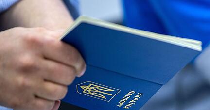 Ein Mann h&auml;lt einen ukrainischen Reisepass in der Hand.