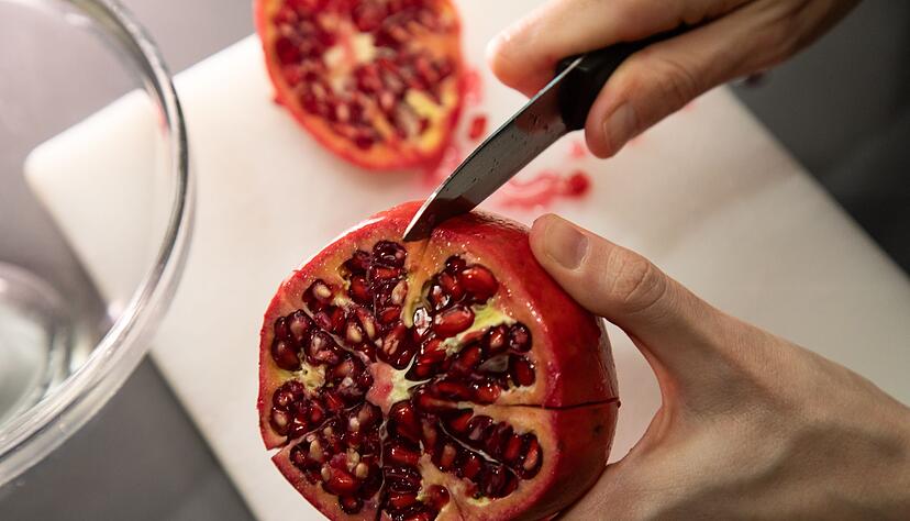 Schritt 2: Den Granatapfel entlang der Kammern einschneiden. Schritt 2: Den Granatapfel entlang der Kammern einschneiden.