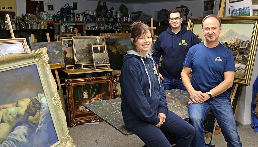Familienbild mit Gemälden: Restaurator Klaus Hub (rechts) in der heimischen Werkstatt in Morsbach mit Ehefrau Andrea, Sohn Luca und einigen der Werke, an denen er zur Zeit arbeitet.
Foto: Armin Rößler