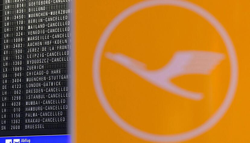 Blick auf Lufthansa-Logo und Anzeigetafel am Frankfurter Flughafen.