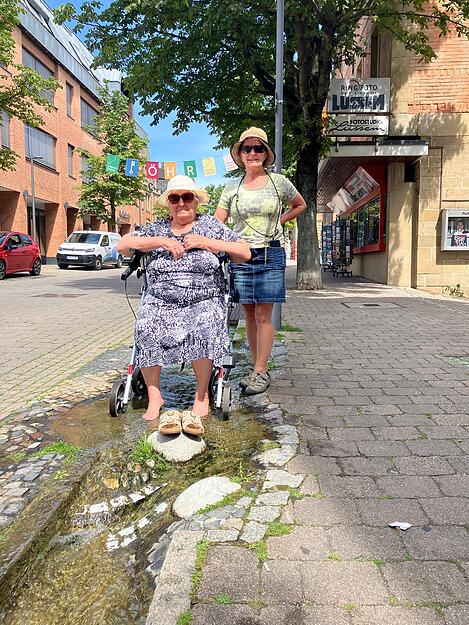 Mariana Olaru ist mit ihrer Mutter Thereza in der Stadt. Die 85-jährige Thereza nutzt den Bachlauf in der Bahnhofstraße, um ihre Füße abzukühlen. Auch das Kneippbecken im Hofgarten ist an heißen Sommertagen beliebter Anlaufpunkt der Öhringer.  Mariana und ihre Mutter geht es nach dem Mittagessen in der Stadt noch zu einer der Eisdielen, verrät Mariana.