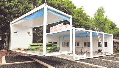 Mit dem Kran werden die Elemente f&uuml;r das zus&auml;tzliche Geb&auml;ude an der Brettachaue aufgesetzt. Am 13. September muss der Innenausbau fertig sein.Foto: Brian Bailey