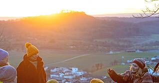 Der Sonnenuntergang bietet die perfekte Kulisse, während die Teilnehmer der Märchenwanderung von Stefanie Keller mit den Bräuchen rund um die Raunächte vertraut gemacht werden.
Fotos: Mario Berger Der Sonnenuntergang bietet die perfekte Kulisse, während die Teilnehmer der Märchenwanderung von Stefanie Keller mit den Bräuchen rund um die Raunächte vertraut gemacht werden.
Fotos: Mario Berger