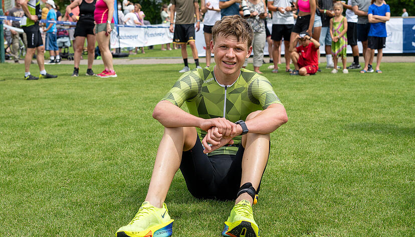 Thorben Scholl lässt sich nach dem Zieleinlauf erst einmal erschöpft auf den Rasen fallen. Der Vorjahressieger ist bei der 34. Auflage des Waldenburger Triathlons noch einmal zwei Minuten schneller als 2024.