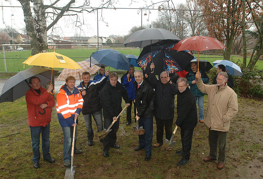 Spatenstich für den Bürgerpark im Februar 2007. Harald Schneider von der Firma Leonhard Weiss, Bauleiter Gunter Jedamzik, Bürgermeister Rüdiger Braun und Planer Dr. Michael Koch (von links) sind von Schirmträgern geschützt.