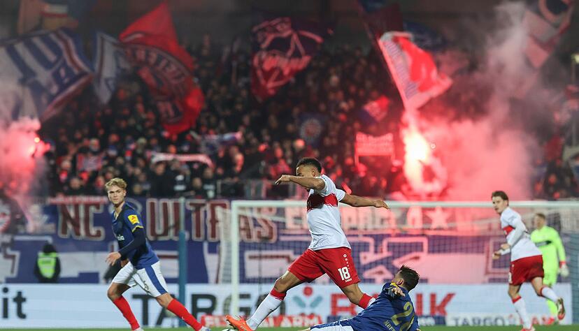 Stuttgarts Jamie Leweling und Kiels Jonas Meffert k&auml;mpfen um den Ball.