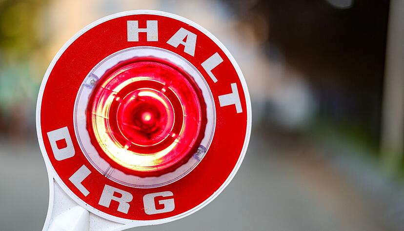 Eine Kelle mit Haltesignal mit Schriftzug der DLRG.