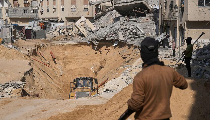 Mitglieder der islamistischen Hamas suchen nach Leichen israelischer Geiseln.