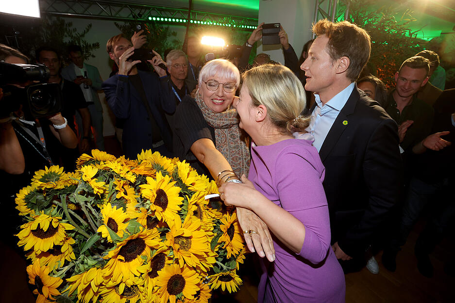 Die beiden Spitzenkandidaten von Bündnis 90/Die Grünen, Katharina Schulze (M) und Ludwig Hartmann freuen sich bei der Wahlparty nach der Bekanntgabe der ersten Prognose zur Landtagswahl in Bayern mit Claudia Roth, der Beauftragten der Bundesregierung für Kultur und Medien.