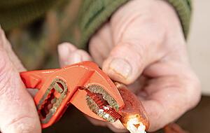 Mit einer Rohrzange knackt Rolf Reichert die Scheren auf.
