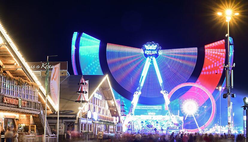 Fahrgeschäfte auf dem Volksfest Cannstatter Wasen bewegen ihre Gondeln.