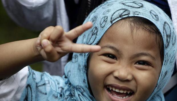 Ein philippinisches M&auml;dchen zeigt das Siegeszeichen bei Feiern zum muslimischen Opferfest nahe Manila. Foto: Dennis M. Sabangan