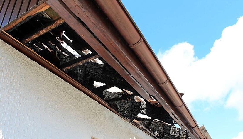 Zwischen den verkohlten Balken ist die Folie zu erahnen, mit denen das Dach des Hauses in Wüstenrot-Neuhütten abgedichtet wurde. Um das Feuer zu löschen und Glutnester zu finden, musste die Feuerwehr es teilweise abdecken.
Foto: Alexander Klug