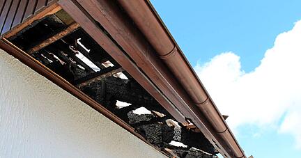 Zwischen den verkohlten Balken ist die Folie zu erahnen, mit denen das Dach des Hauses in Wüstenrot-Neuhütten abgedichtet wurde. Um das Feuer zu löschen und Glutnester zu finden, musste die Feuerwehr es teilweise abdecken.
Foto: Alexander Klug